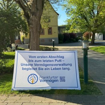 Werbebanner eines Vermögensverwalters auf einem gepflegten Gelände mit Bäumen und Gebäuden im Hintergrund.