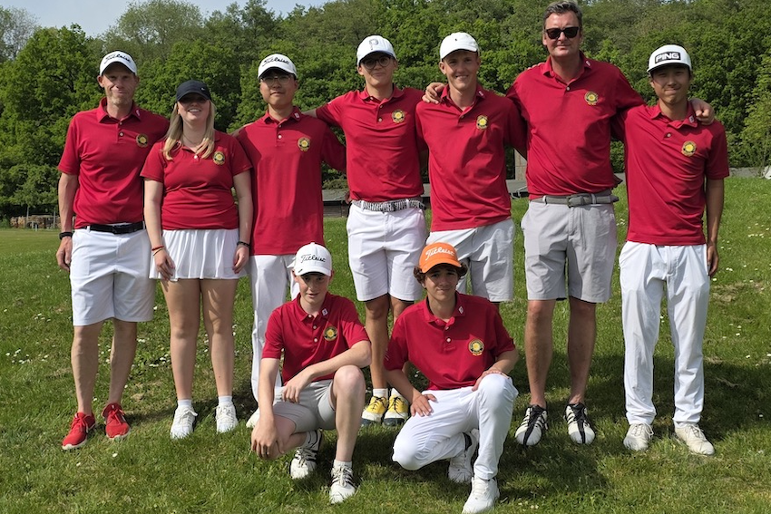 Jugendspielerinnen, Jugendspieler und Trainer des Golfclubs stehen gemeinsam in roten Teamshirts auf dem Golfplatz für ein Gruppenfoto.