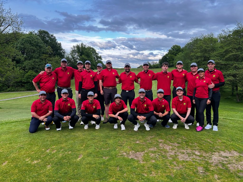 Gruppenfoto der DGL-Herrenmannschaft und des Betreuerteams nach dem 1. Spieltag im GC Weiherhof auf dem Golfplatz vor bewölktem Himmel.