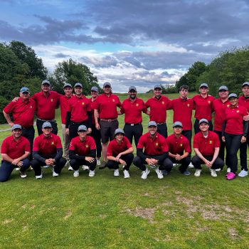 Gruppenfoto der DGL-Herrenmannschaft und des Betreuerteams nach dem 1. Spieltag im GC Weiherhof auf dem Golfplatz vor bewölktem Himmel.
