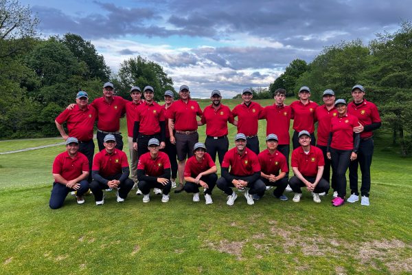 Gruppenfoto der DGL-Herrenmannschaft und des Betreuerteams nach dem 1. Spieltag im GC Weiherhof auf dem Golfplatz vor bewölktem Himmel.
