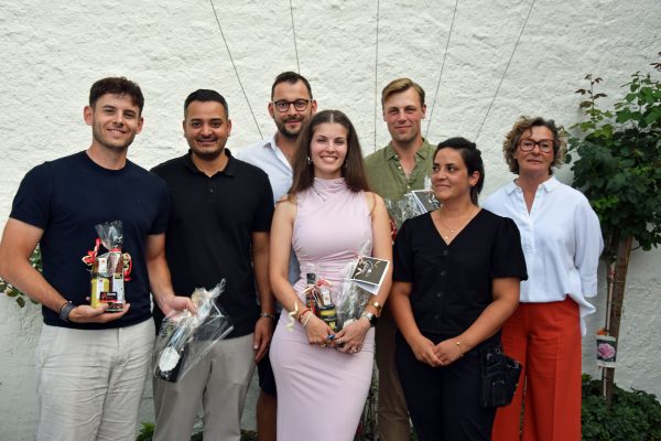 Gruppenfoto der Bruttosieger beim Turnier „Preis des Herrenhauses" 2026, sieben Personen mit Geschenkkörben vor einer weißen Hauswand.